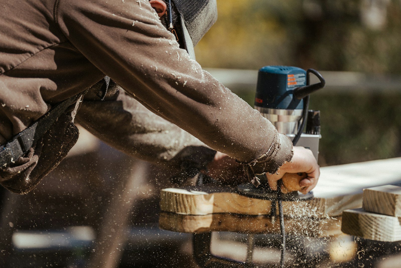 a man sanding a piece of wood with a sander, contractor